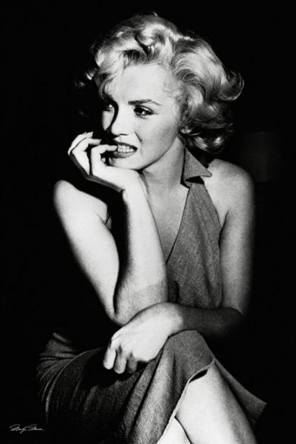 Czarno-biały plakat z Marilyn Monroe siedzącą w eleganckiej suknii