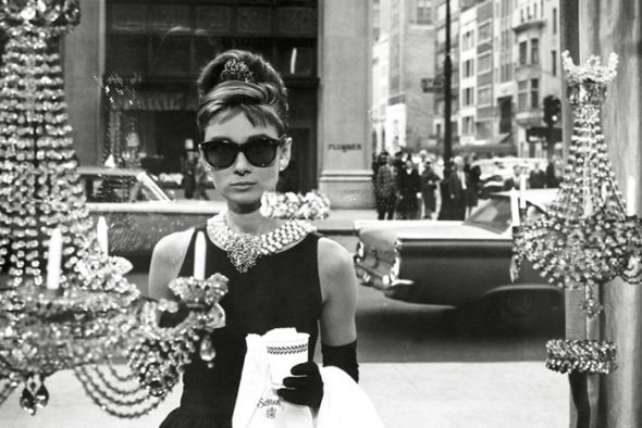 Czarno-biały plakat ścienny z Audrey Hepburn w ciemnych okularach w oknie