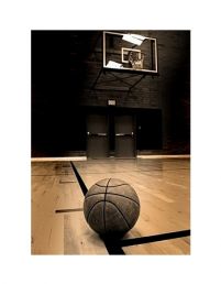 reprodukcja ze zdjęciem piłki do gry w koszykówkę leżącą na parkiecie hali sportowej na tle czarnych dużych drzwi i obręczy kosza