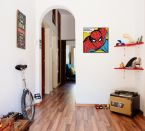 Canvas ze Spidermanem na tle komiksu zawieszony w pokoju chłopca obok półek z figurkami