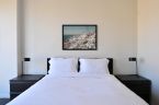 Plakat z malowniczym Santorini powieszony w sypialni nad łóżkiem