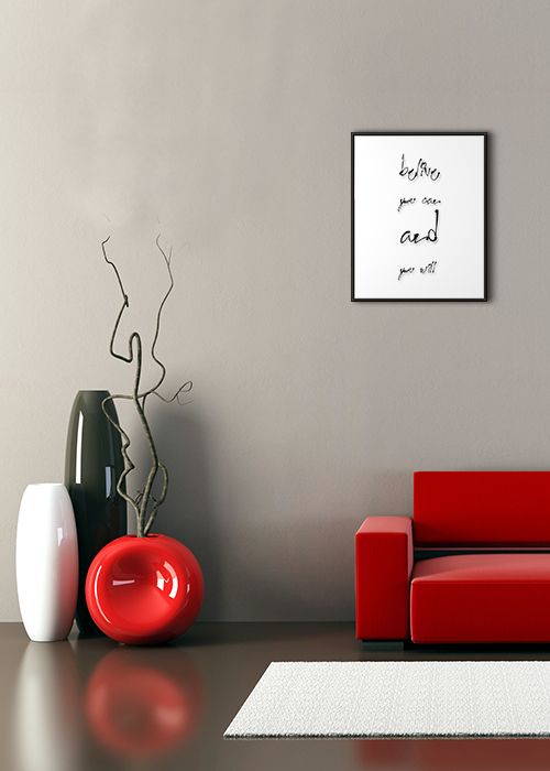 aranżacja plakatu z motywacyjnym napisem na białym tle i w czarnej ramie wiszącym na szarej ścianie w pokoju nad czerowną sofą i wazonami