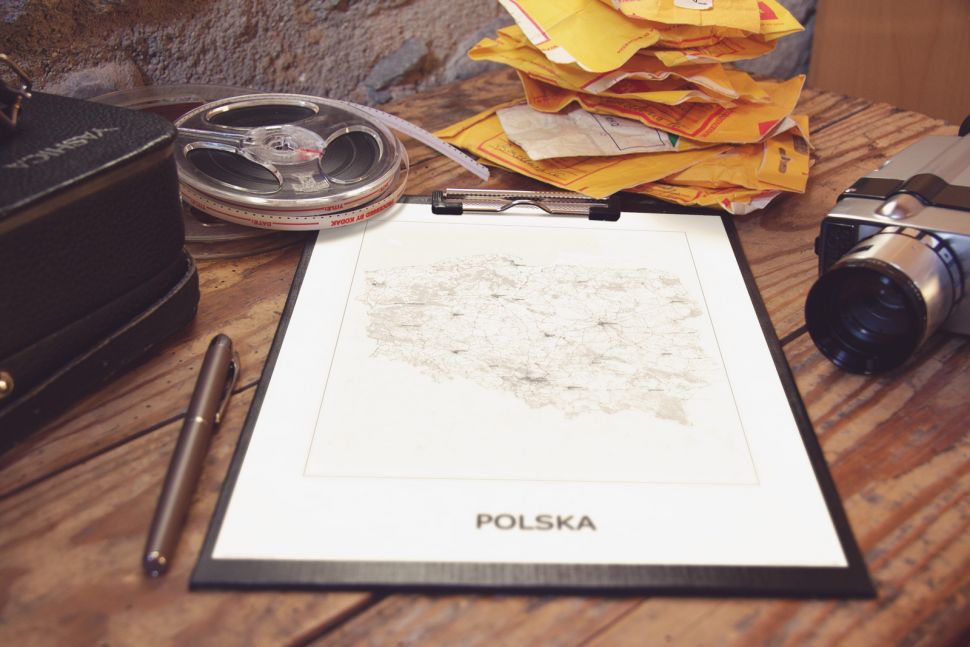 mapa polski leżąca na biurku, wpięta w segregator