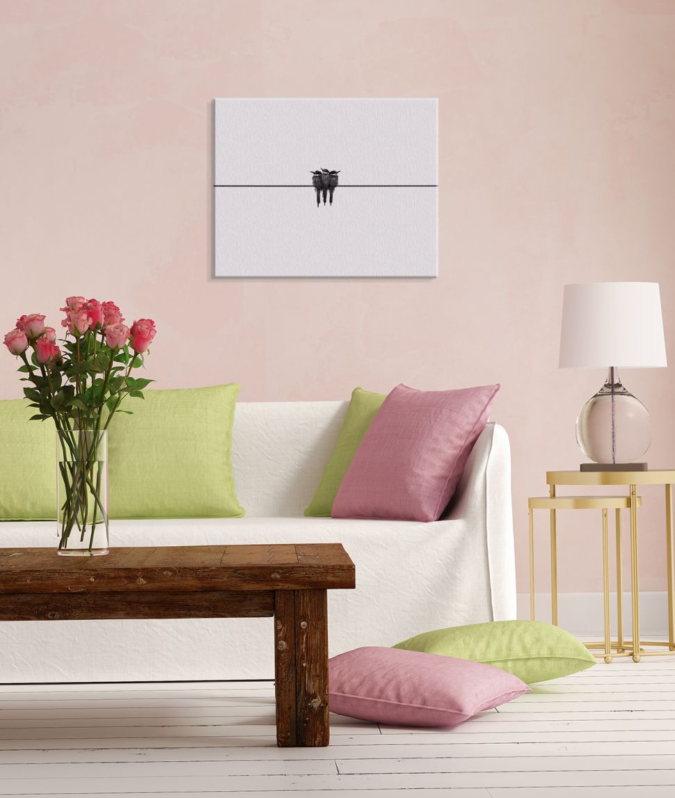 Obraz na płótnie Black swallow wiszący na różowej ścianie nad białą kanapą