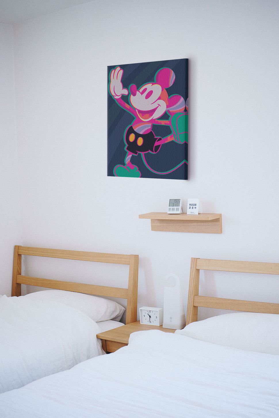 Obraz na płótnie z kolorową Myszką Miki powieszony na białej ścianie w sypialni