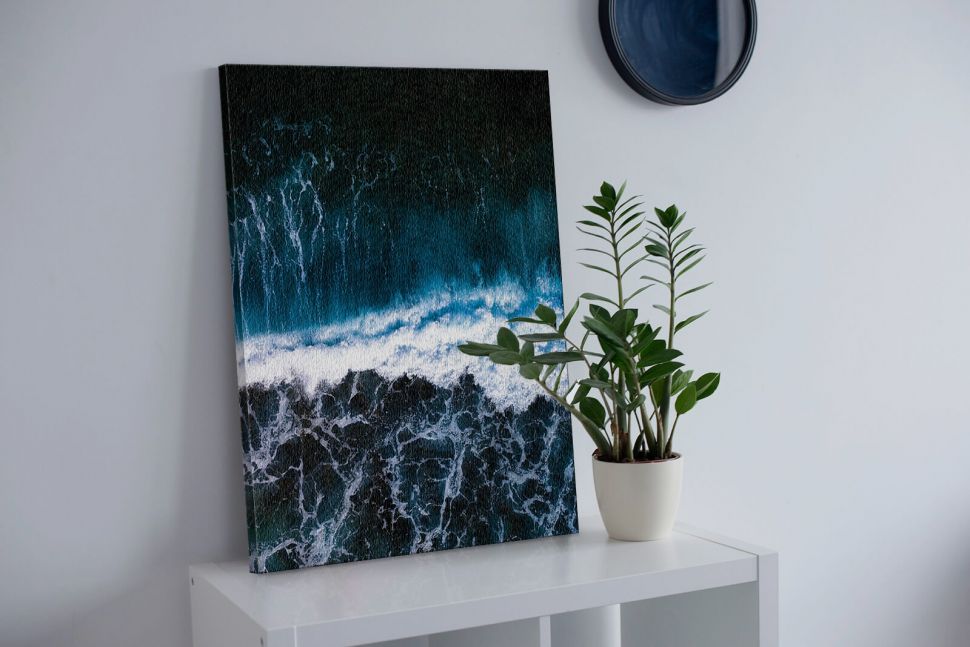 Obraz na płótnie Wzburzone Morze postawiony na białej szafce obok kwiatka