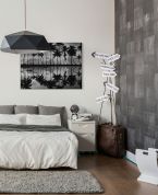 Canvas przedstawiający palmy i wodę powieszony na ścianie w sypialni